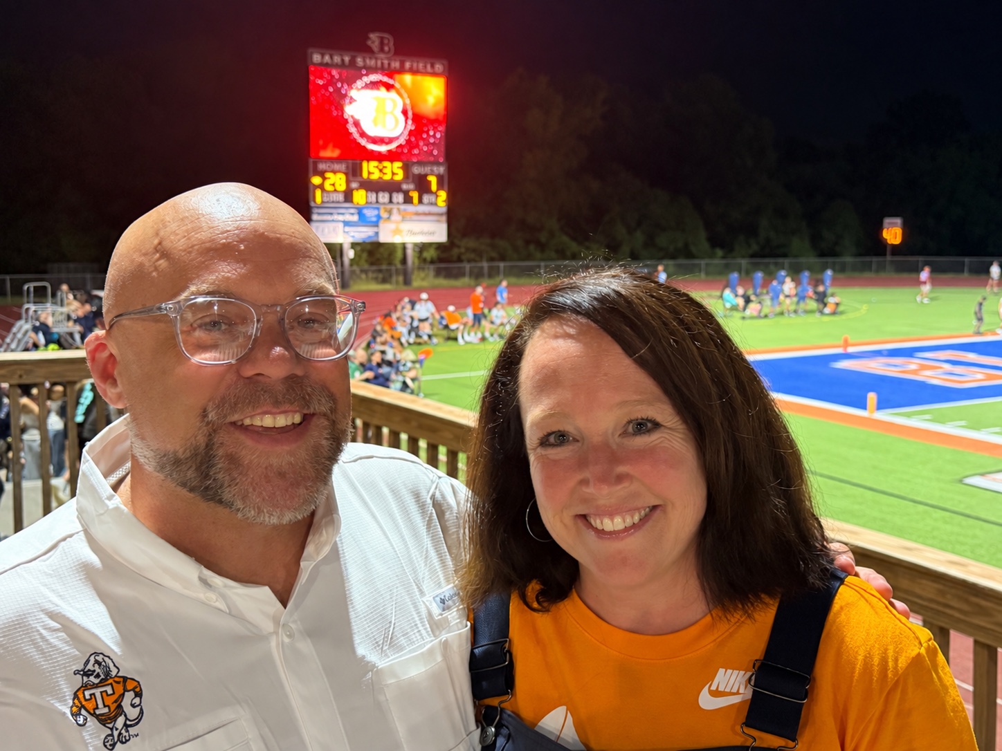 Two parent volunteers behind Video Board Graphics at a Blackman Blaze football game